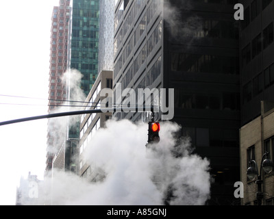 Dampf steigt von der Straße und rund um die rote Ampel, New York City Amerika USA Stockfoto