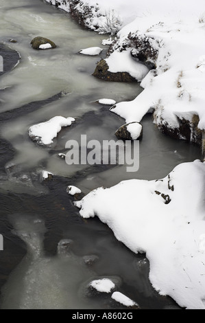 Eine teilweise zugefrorenen Fluss in den Cairngorms, den Fluss Clunie in der Nähe von Braemar im Schnee. Stockfoto