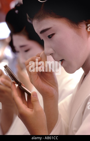 Ein Maiko oder Lehrling Geisha, Pudern ihre Nase während einer Pause bei einem Festival in Kyoto Stockfoto