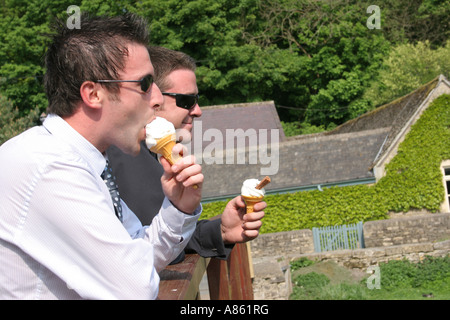 Zwei Männer essen Eis an einem heißen Tag in Bibury Gloucestershire. Stockfoto