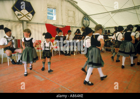 Kinder tanzen in bayerischer Tracht zu traditioneller Musik auf dem Oktoberfest in München Stockfoto