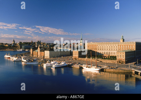 Boote verankert entlang Skeppsbron bei Sonnenaufgang mit Königspalast und Old Town in Stockholm Stockfoto