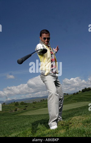 Porträt eines jungen Mannes mit einem Golfschläger posiert. Stockfoto