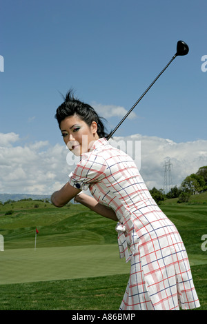 Porträt einer jungen Frau posiert mit einem Golfschläger. Stockfoto