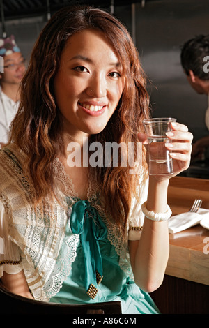 Junge Asiatin mit Glas, close-up Stockfoto