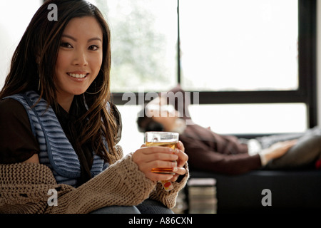 Junge Frau mit Glas und Mann mit Kopfhörer, Porträt Stockfoto