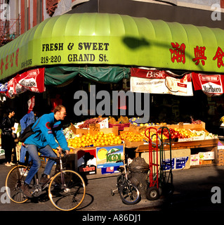 Man fährt mit dem Fahrrad am Frische and Sweet Obststand in der 218-220 Grand Street im New Yorker Viertel Chinatown in Lower Manhattan vorbei. Stockfoto