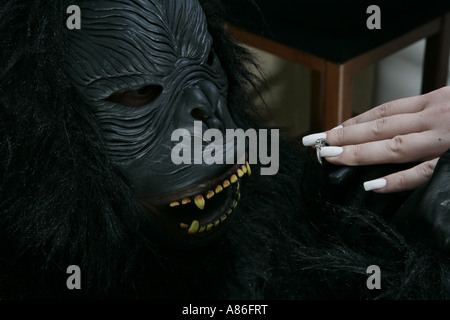 Ein Mann in eine Gorillamaske schlägt vor, eine Frau Stockfoto