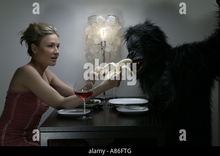 Eine Frau ist einen Mann ein Gorilla Kostüm Fütterung. Stockfoto