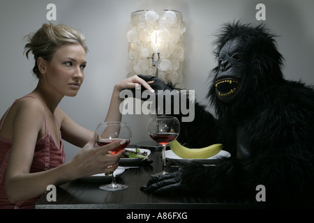 Eine Frau ist mit einem Mann im Gorilla-Kostüm Essen. Stockfoto