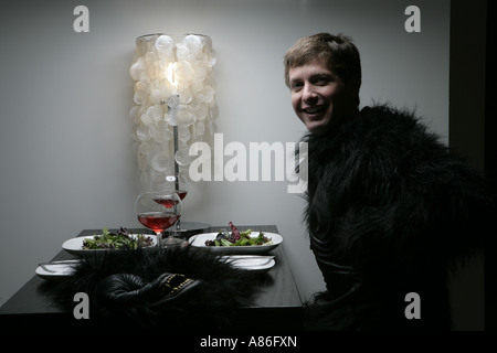 Mann im Gorilla-Kunden allein am Tisch sitzen Stockfoto
