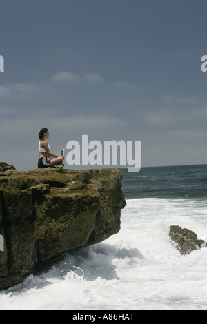 Blick auf eine Frau, die arbeitet auf einem Laptop in der Nähe eines Meeres. Stockfoto