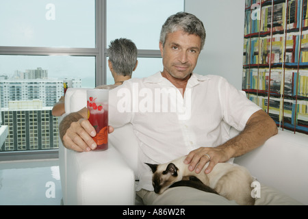 Zwei Erwachsene sitzen Rücken an Rücken in einen Sessel Stockfoto