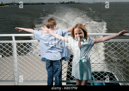 Zwei Kinder auf einem Boot mit ihren ausgestreckten Armen Stockfoto