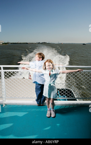 Zwei Kinder auf einem Boot, mit ausgestreckten Armen Stockfoto