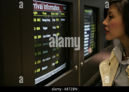 Eine junge Frau liest Zeitpläne. Stockfoto