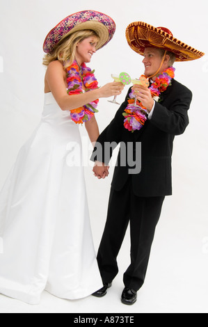 Braut und Bräutigam tragen Sombreros und Blumengirlanden und Toasten Stockfoto