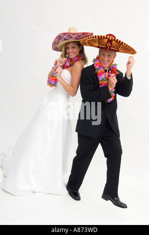 Braut und Bräutigam tragen Sombreros und Blumengirlanden beim Tanzen Stockfoto