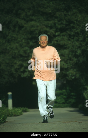 Ein Lächeln auf den Lippen Senioren männlich 70er Jahre 73 Jahre alte Jahre tragen Schweiß Hose orange t Shirt Joggen hinunter einen Weg in einem Park kaukasische POV Herr © Myrleen Pearson