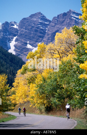 Drei Menschen auf Fahrrädern durch Aspen Bäume und Berge im Hintergrund White River National Forest Rocky Mountains Stockfoto