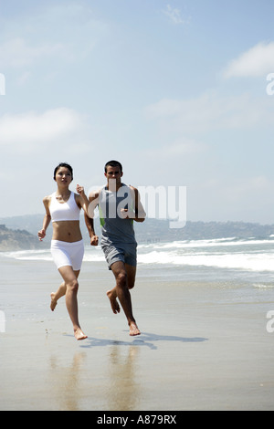 Ein paar sind zusammen am Strand joggen. Stockfoto