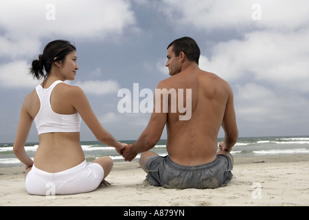 Ein paar sitzen zusammen an einem Strand. Stockfoto