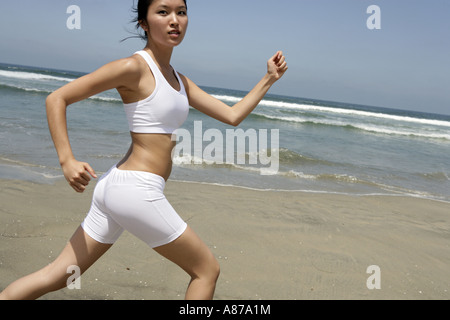 Eine junge Frau läuft auf einem Strand. Stockfoto