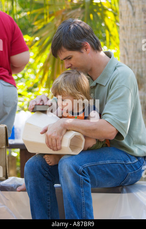 Vater hilft jungen Mädchen, Holztrommeln für das Malen vorzubereiten, bei der Homeschool Drum Building-Veranstaltung in Zentral-Florida, USA Stockfoto