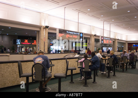 Reisende, die im Café des Flughafenterminals sitzen und auf Abflug oder Ankunft von Flügen am Tampa International Airport, Florida, USA warten Stockfoto