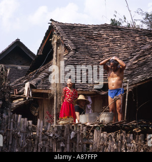 Lokale Mann unter der Dusche vom Standrohr vor seinem Haus, Familie auf, in der Nähe von Jinghong, China Stockfoto