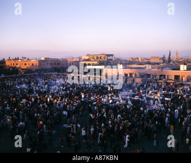 Menschen füllen Djemma El Fna entfernt als die Sonne untergeht und Garküchen verkaufen Mahlzeiten, Marrakesch, Marokko Stockfoto