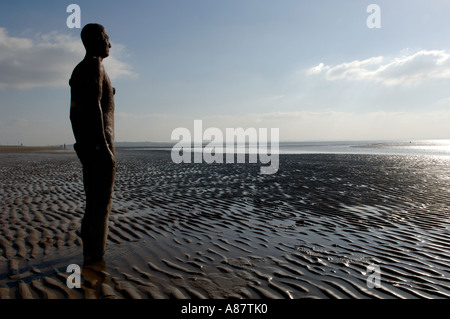 Eine Figur aus dem Kunstwerk Another Place von Anthony Gormley am Crosby Strand Merseyside. Stockfoto