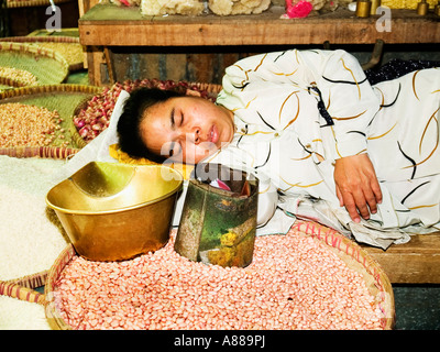 Lokale Frau, die eine Siesta unter die Impulse an ihrem Stand in der Markthalle, Madiun, Java, Indonesien Stockfoto