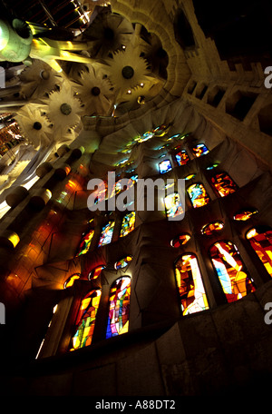 Gebrochenes Licht durch die bunten Glasfenster in der unvollendeten Temple de la Sagrada Familia, Barcelona, Spanien Stockfoto