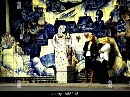 Zwei Frauen stehen auf Bürgersteig vor blau-weiße Keramik gefliest Szene, entlang der Straße in Sankt Petersburg, Russland Stockfoto