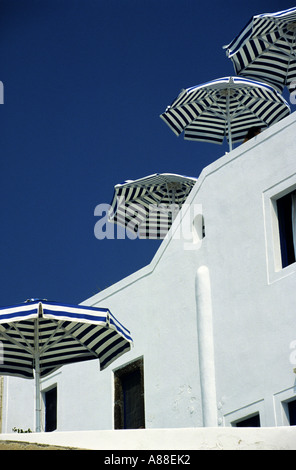 Blau-weiß gestreifte Sonnenschirme am Dach des Hotels in Fira, Santorini, griechische Inseln, Griechenland Stockfoto