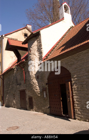 Altes Eingangstor in Tallinn Estland, mit historischen Steinmauern, Bogenholztüren und traditionellen roten Ziegeldächern an einem sonnigen Tag. Stockfoto