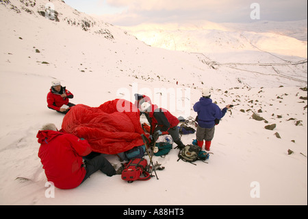 eine Bergrettung retten einen gefallenen Wanderer auf roten Geröllhalden, Lake District, Cumbria, UK Stockfoto