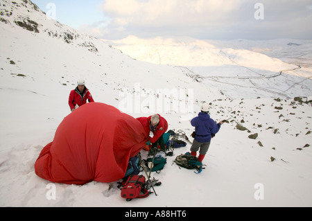 eine Bergrettung retten einen gefallenen Wanderer auf roten Geröllhalden, Lake District, Cumbria, UK Stockfoto