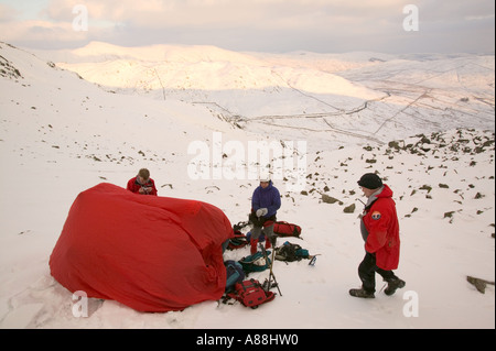 eine Bergrettung retten einen gefallenen Wanderer auf roten Geröllhalden, Lake District, Cumbria, UK Stockfoto