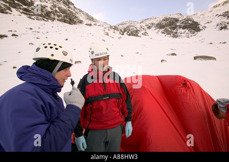 eine Bergrettung retten einen gefallenen Wanderer auf roten Geröllhalden, Lake District, Cumbria, UK Stockfoto