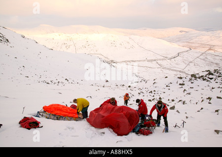 eine Bergrettung retten einen gefallenen Wanderer auf roten Geröllhalden, Lake District, Cumbria, UK Stockfoto