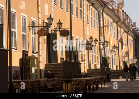 Historische gelbe alte Häuser in der Tornu Straße in der Altstadt von Riga, Lettland, mit Cafés im Freien und traditionellen Straßenlaternen. Stockfoto
