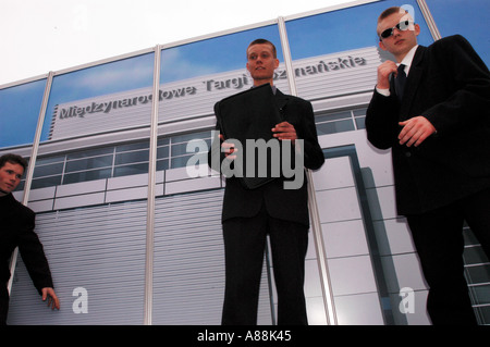 Junge Geschäftsleute posieren vor dem Poznan International Fair Gebäude in Poznan, Polen. Flachwinkelansicht von Profis in Anzügen. Stockfoto
