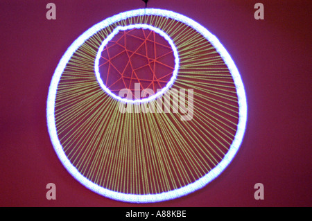 Psychedelische Wandmalereien in Trance-Partys mit leuchtenden, kreisförmigen Stringbildern mit Neonlichtern auf rotem Hintergrund. Stockfoto