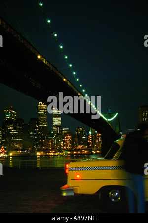 Mann Taxi unter der Brooklyn Bridge mit niedrigeren Skyline von Manhattan über den East River New York City New York USA Stockfoto