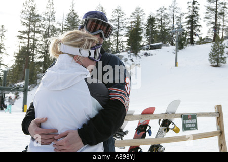 Paar auf einer Skipiste umarmt Stockfoto