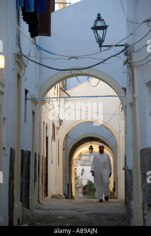 Mann geht entlang einer schmalen Gängen unter Bögen Medina Tripolis Libyen Stockfoto