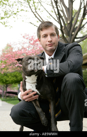 Business-Mann hält einen Hund Stockfoto