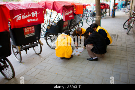 CHINA Peking Hutong Rikscha Fahrer Chinese Checkers auf dem Bürgersteig zu spielen, während sie warten, Kunden Bereich Hutong Tour Stockfoto